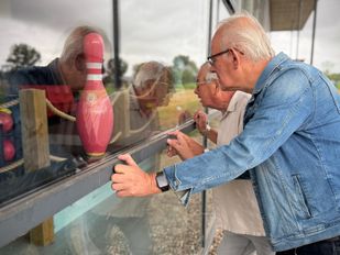Secretaris Hanjo van den Wijngaart en voorzitter Ad van Zitteren kijken naar binnen bij de gesloten bowlingbaan in Tholen.