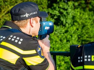 Agent met snelheidsmeter op viaduct