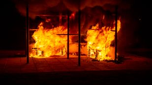 Tegen een donkere nachtlucht vernielen rood-oranje vlammen het klimrek op de Jongerenontmoetingsplek in Roosendaal